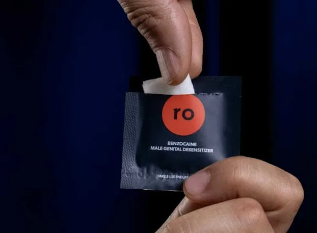 Man holding Benzocaine wipe with SOCOman swipe packet